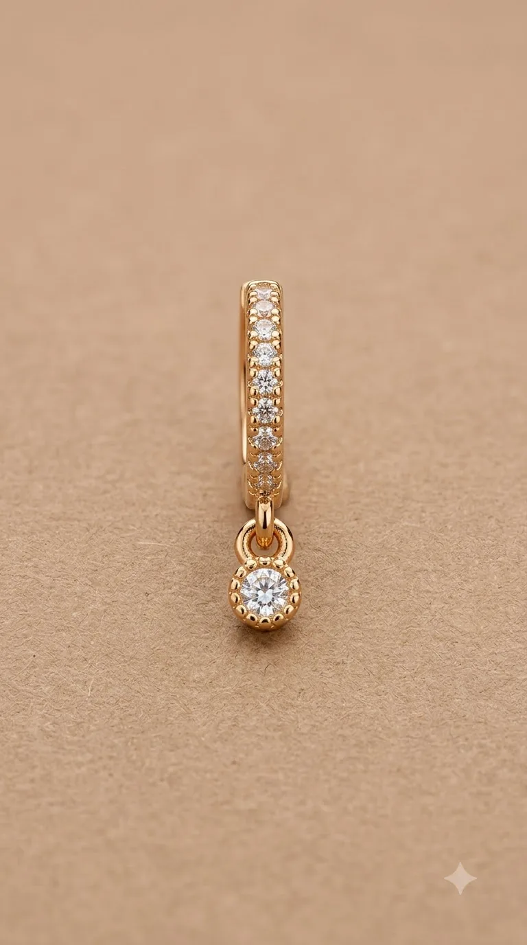 Gold-tone pavé huggie hoop earring with a round crystal charm drop