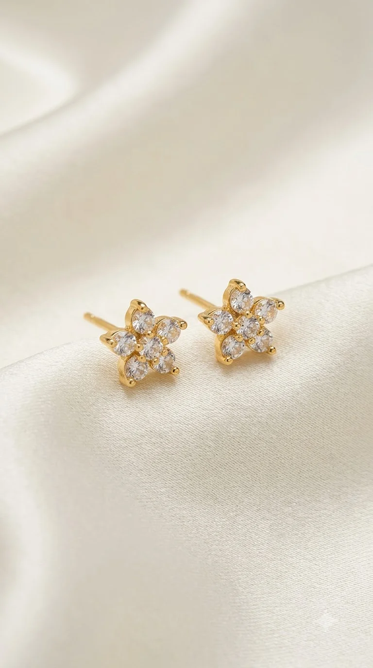 AASHORA Starbloom gold-tone stud earrings featuring sparkling clear crystals in an elegant floral-star design.