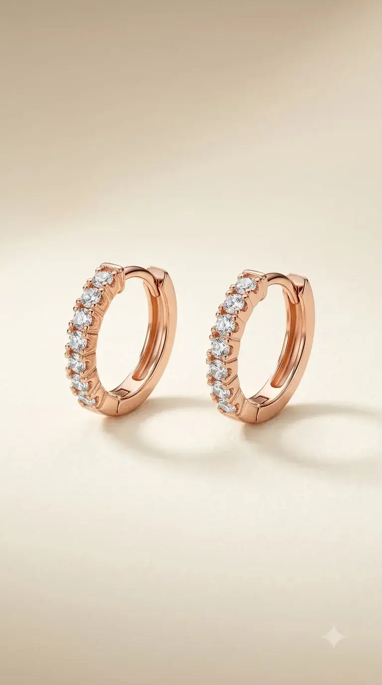 Rose gold huggie hoop earrings lined with crystals on ivory fabric
